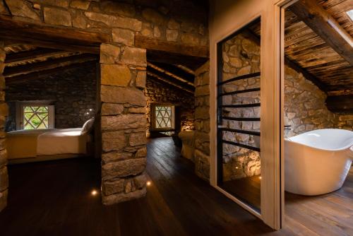 Campiglia CervoCountry House La Bursch的一间石墙浴室和一个浴缸