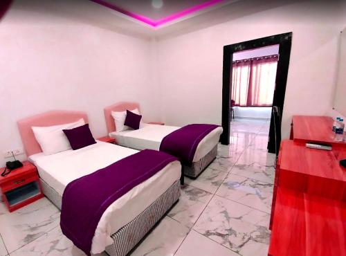 加雅The Buddha Resort的紫白色客房的两张床