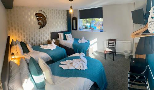Saltford临江旅馆的一间设有三张床的房间,上面有天鹅