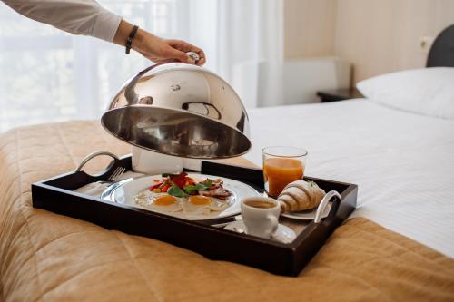 特鲁斯卡韦茨Курортний Готель Золота Корона的床上的早餐托盘,包括鸡蛋和咖啡