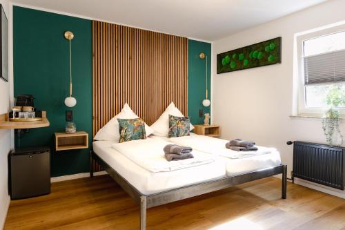 瓦尔内明德Alex & Rine - Pension Zum Alten Strom的绿色墙壁间的一张床位
