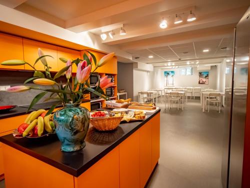 戛纳BANANA'S CAMP的厨房配有橙色橱柜和花瓶