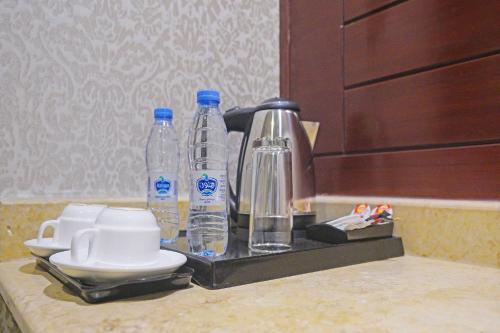 吉达EKONO by Leva Jeddah Airport Hotel的配有2瓶水的柜台和咖啡设施