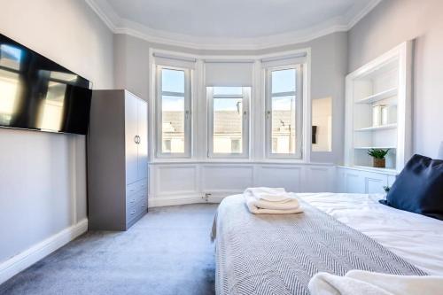 威萧Kali Apartment - Spacious 3 bed apartment in Wishaw的一间卧室配有一张床,上面有两条毛巾