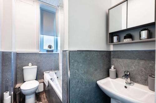 威萧Kali Apartment - Spacious 3 bed apartment in Wishaw的一间带卫生间、水槽和镜子的浴室