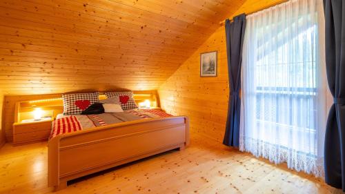 SittersdorfFerienhaus Rauscher的木制客房内的一间卧室,配有一张床