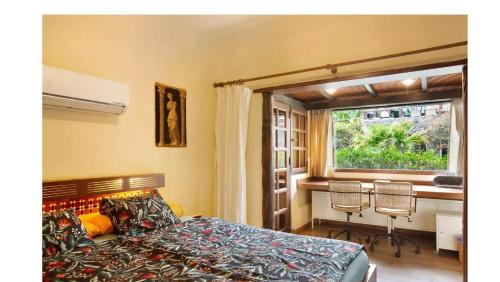 阿吉拉海滩VCV VILLA BAHÍA FELIZ的一间卧室配有一张床、一张桌子和一个窗户。