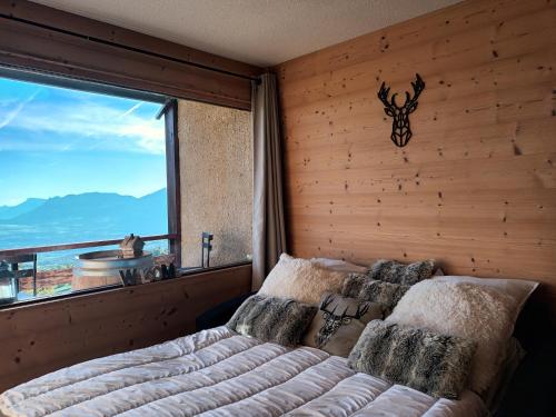 圣米舍德谢洛appartement montagne- le petit Chaillol的一间卧室设有一张床和一个大窗户