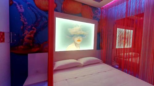 奇尼塞洛巴尔萨莫C rooms - Love Motel Monza的一间房间,床上挂着一张女人的照片