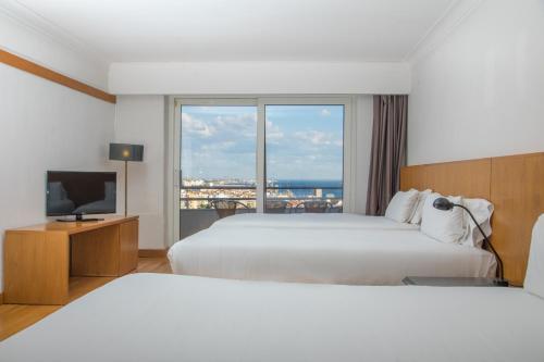 塞图巴尔B&B HOTEL Sado Setúbal的酒店客房设有两张床和电视。