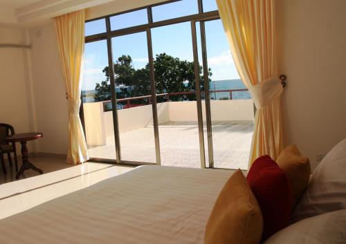 努库阿洛法翡翠酒店及餐厅的一间卧室设有一张床和一个大窗户