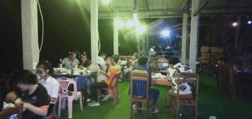 北宾Villa Mekong Guesthouse的一群坐在餐厅桌子上的人