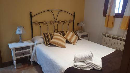 昆卡Las Torres的卧室配有一张带枕头和毯子的大床