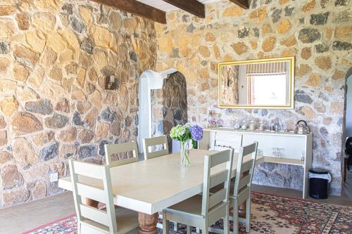 安德伯格Dragons Landing Guest Farm的一间设有桌椅和石墙的用餐室