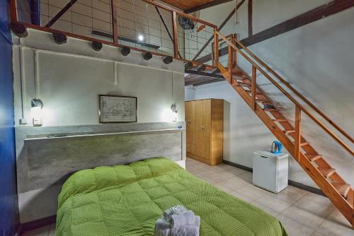 维多利亚El Molino - Complejo Turístisco的一间卧室设有一张绿色的床和一个楼梯。