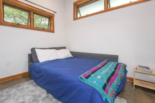 波特兰Private Studio, Lofted Bed, Soaking Tub & Patio的一间卧室配有一张带蓝色毯子的床