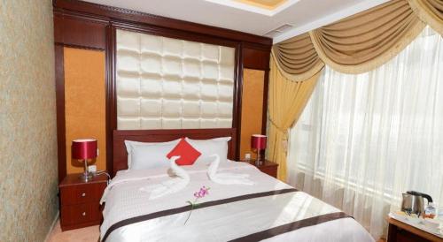 科威特Relax inn Apartment - Fahaheel的卧室配有带红色枕头的大型白色床