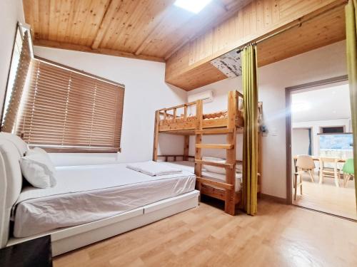 济州市济州吉琳住宿加早餐旅馆的一间卧室配有一张双层床和梯子