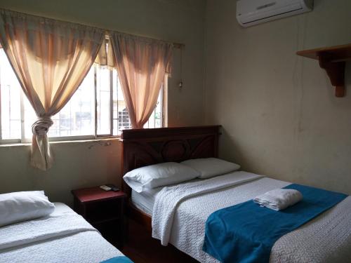 阿约拉港Hostal Miconia的一间卧室设有两张床和窗户。