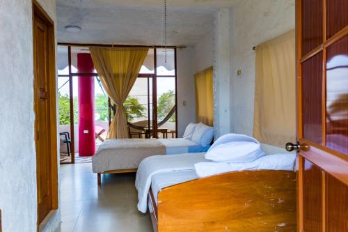 巴克里索莫雷诺港Royal Galápagos Inn的一间带两张床的卧室和一间带窗户的房间