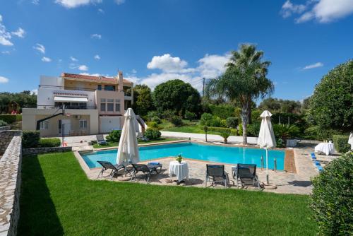阿斯特里昂Villa Anna with Private Pool, Play area & BBQ, 5km from the Beach的房屋旁的游泳池配有椅子和遮阳伞