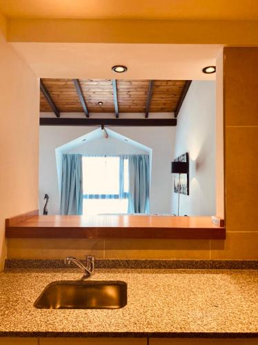 圣卡洛斯-德巴里洛切Tucuman Suite Bariloche的带镜子的厨房内的盥洗盆
