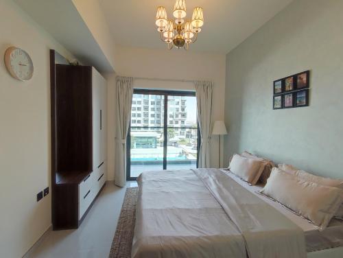 迪拜5*Amenities-2Br-15 min DxbApt,20min to Dubai Mall的一间卧室配有一张大床和一个吊灯。