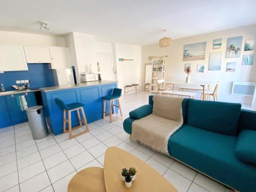 鲁瓦扬Le Pontappart的一间带蓝色沙发的客厅和一间厨房
