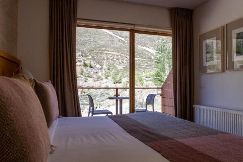 Refugio Lo ValdésLodge El Morado的酒店客房设有一张床和一个大窗户