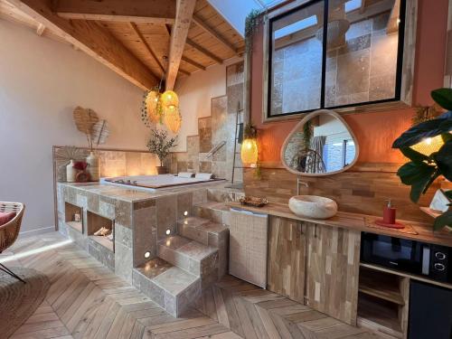 昂热Suite Bali Les Petits Plaisirs的厨房配有石制柜台和镜子