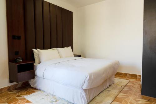 拉各斯Jotani Living的卧室配有一张白色大床和木制床头板