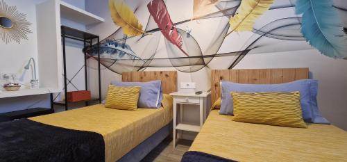 韦尔瓦Huelva Art的一间卧室设有两张床和一堵风筝墙
