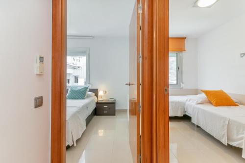 锡切斯锡切斯帆船租赁酒店的一间卧室配有两张床和镜子