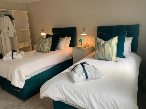 索尔兹伯里Hideaway Holiday Apartment的一间卧室配有两张带蓝白色枕头的床