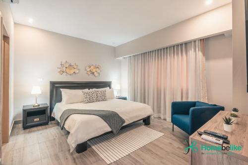 Los PradosChic Fully Serviced Apartment at Regatta Living II - 705的一间卧室配有一张床和一张蓝色椅子