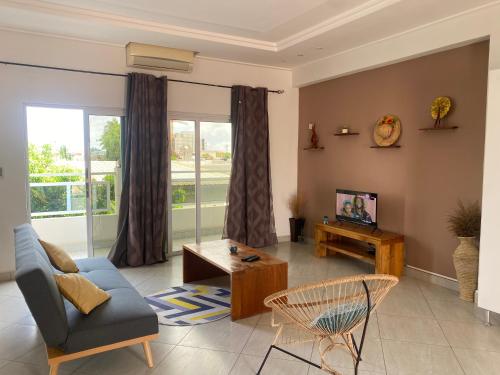 科托努L'Oasis Guesthouse的带沙发和电视的客厅