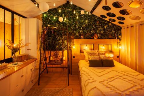 昂热Love Room Romantique Les Petits Plaisirs的卧室配有一张挂在墙上的植物床