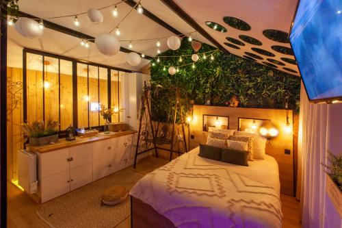 昂热Love Room Romantique Les Petits Plaisirs的卧室配有一张挂在墙上的植物大床