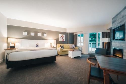 惠斯勒惠斯勒山峰木屋精品酒店的大型酒店客房,配有床和沙发