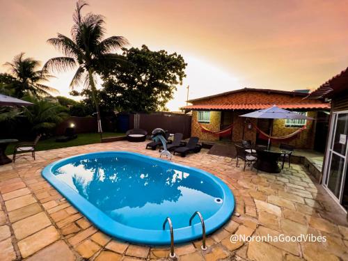 费尔南多 - 迪诺罗尼亚Noronha Good Vibes Hostel的庭院中间的游泳池