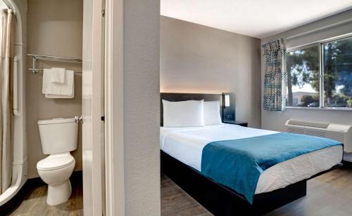 贝克斯菲尔德Motel 6-Bakersfield, CA - South的一间卧室设有一张床、一个卫生间和一个窗口