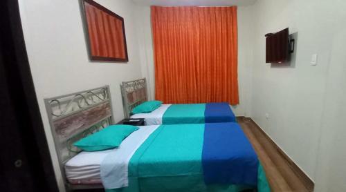 伊察Diamond Monkey Lodge的一间卧室配有两张带蓝色和绿色床单的床