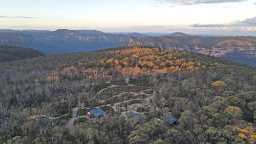 黑荒地Chalets at Blackheath的享有森林的空中景色,在山丘上设有房屋