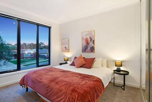 ThebartonLinear Park Living - Brand New 4 Bed Family Home的一间卧室设有一张床和一个大窗户