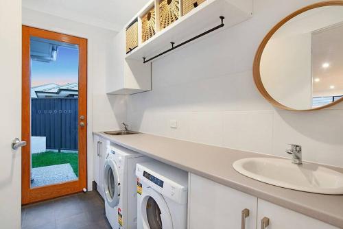 ThebartonLinear Park Living - Brand New 4 Bed Family Home的一间带水槽和洗衣机的浴室