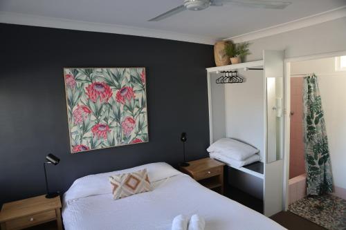 米塔贡梅尔罗斯汽车旅馆 的卧室配有一张床,墙上挂有绘画作品