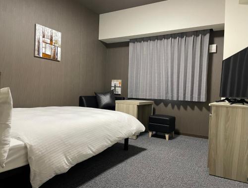 四国中央市Hotel Route Inn Shikoku Chuo的酒店客房,配有床和电视