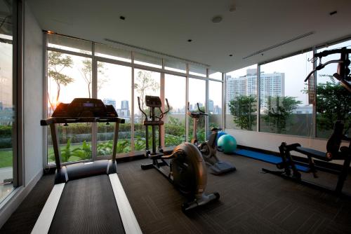 曼谷曼谷茉莉花度假酒店的健身房设有两个跑步机和大窗户