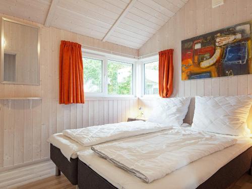 格洛米茨Three-Bedroom Holiday home in Grömitz 13的卧室在窗户前配有一张大床