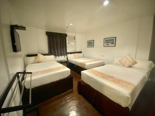 长滩岛Emerald Bay Boracay的酒店客房设有两张床和一个阳台。